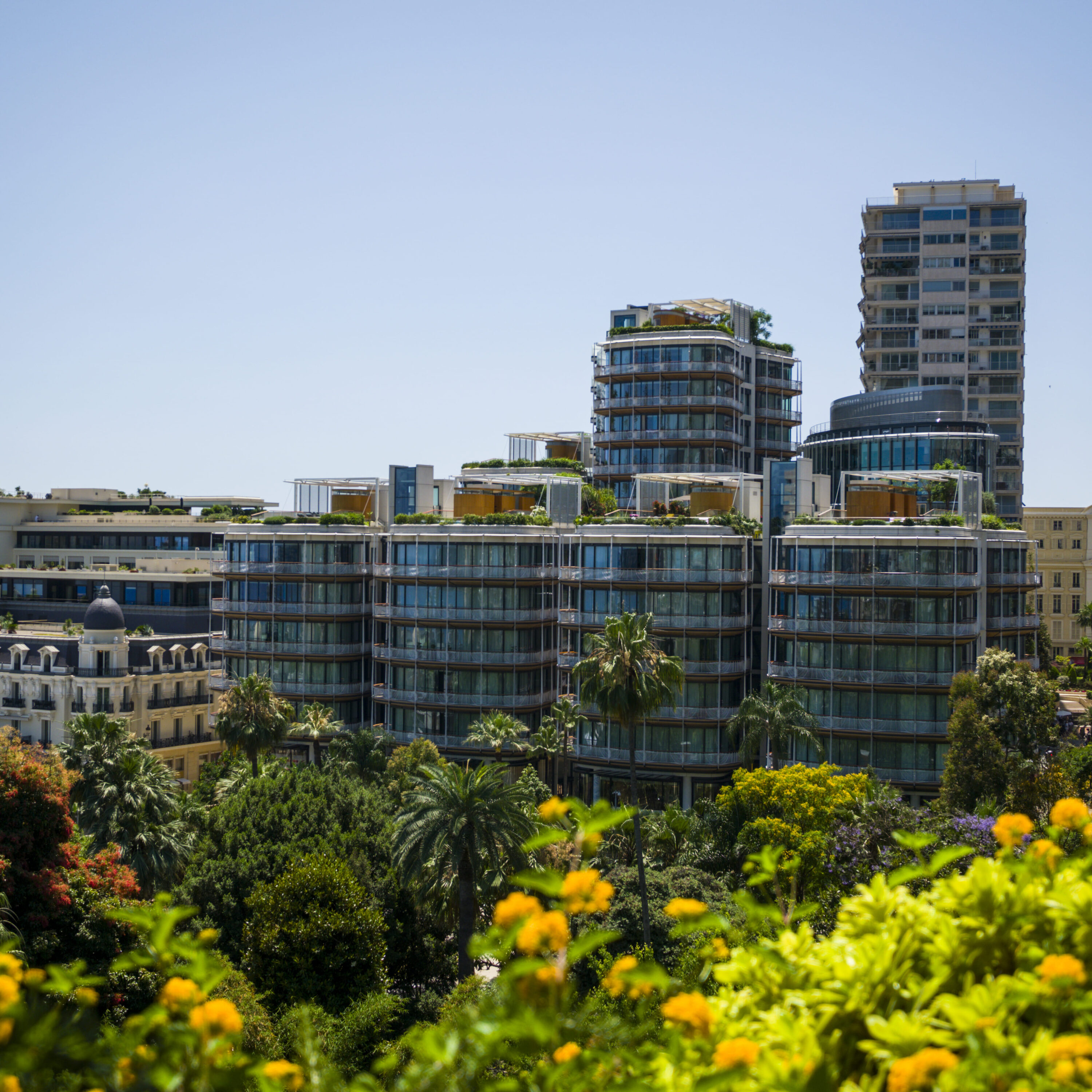 Moderne Monegaskische appartementsgebouwen met begroeide dakterrassen, gezien boven subtropische tuinen