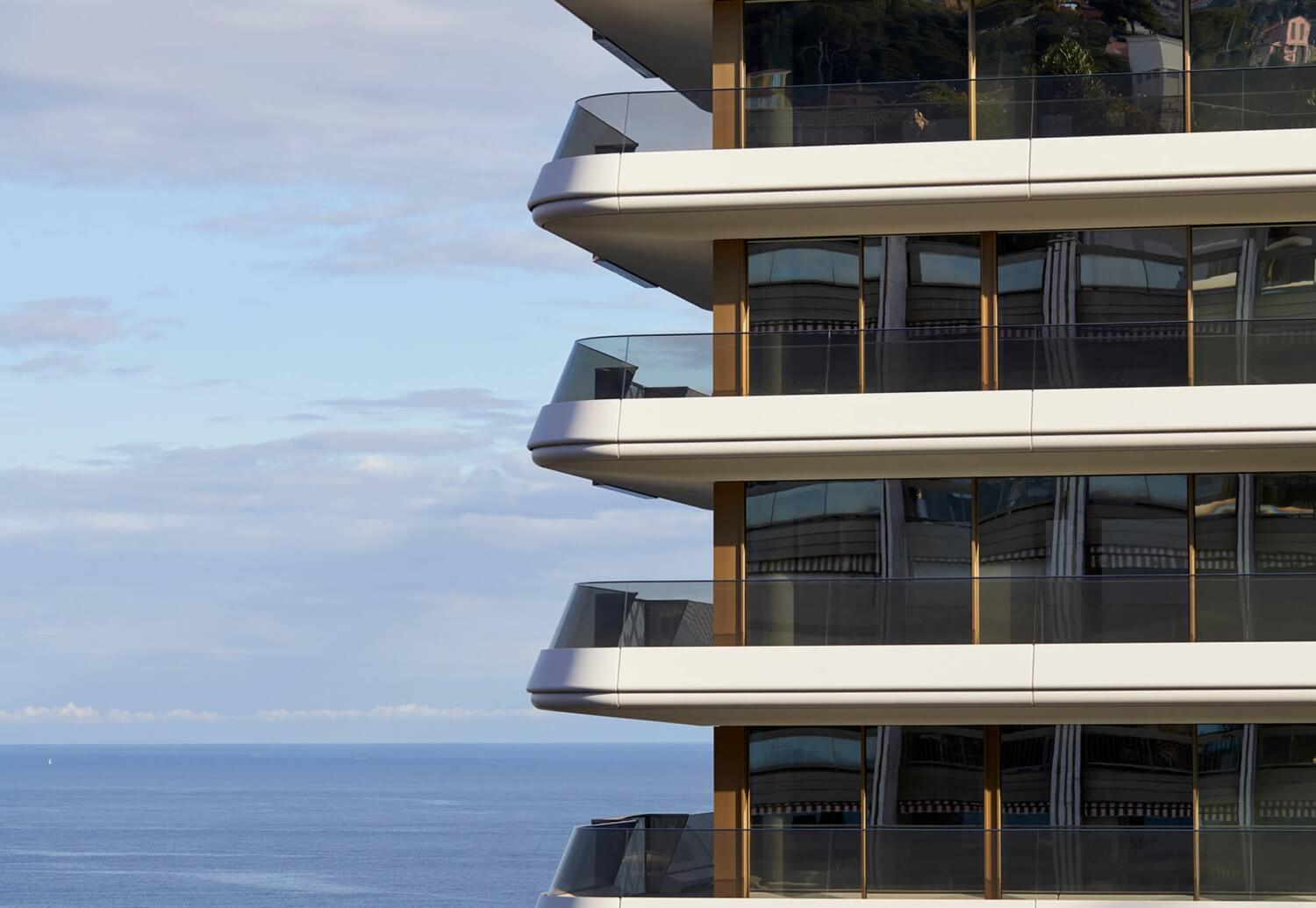 Balconi curvi in vetro di un edificio residenziale contemporaneo affacciato sul Mediterraneo a Monaco